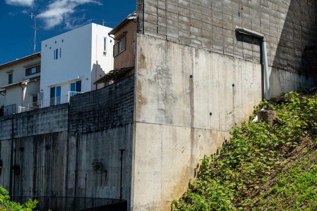 古い擁壁の上に建つ家